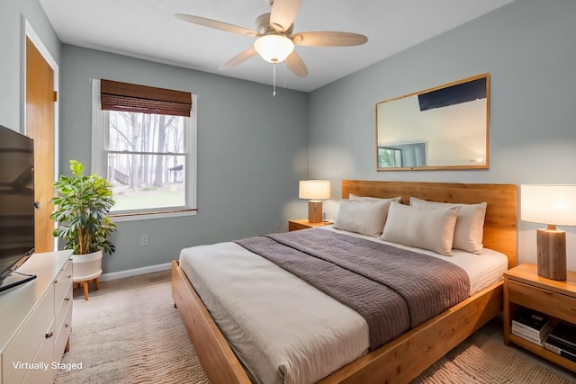 bedroom featuring light colored carpet, ceiling fan, and baseboards