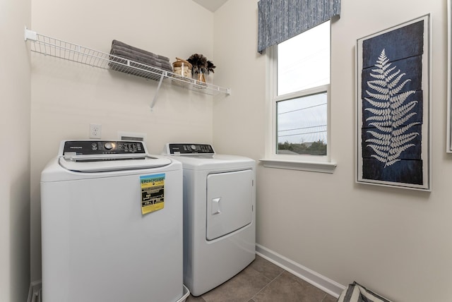 washroom with baseboards, laundry area, dark tile patterned flooring, and washer and dryer