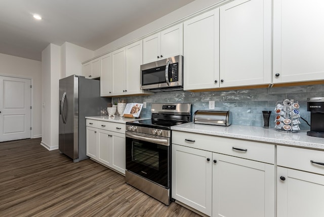 kitchen with backsplash, white cabinetry, stainless steel appliances, and dark wood finished floors