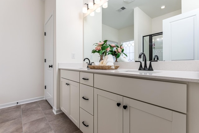 bathroom with double vanity, visible vents, a sink, a shower stall, and tile patterned floors