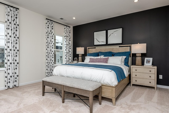 carpeted bedroom featuring baseboards, multiple windows, and visible vents