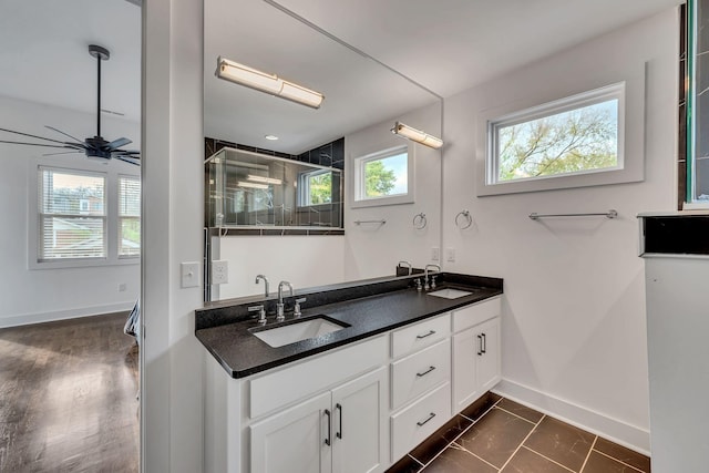 full bathroom with a sink, baseboards, and double vanity