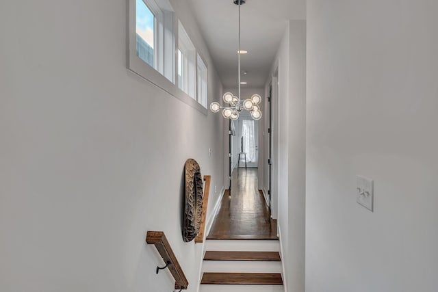 staircase with a notable chandelier