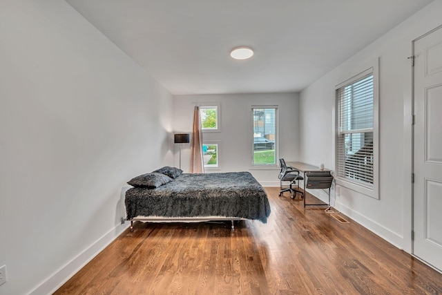 bedroom with wood finished floors and baseboards