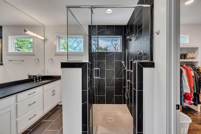 bathroom with recessed lighting, a shower stall, vanity, and a spacious closet