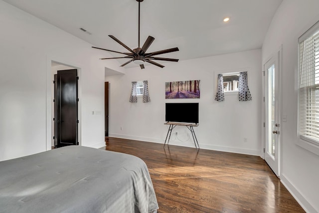 bedroom featuring dark wood-style floors, multiple windows, visible vents, and baseboards