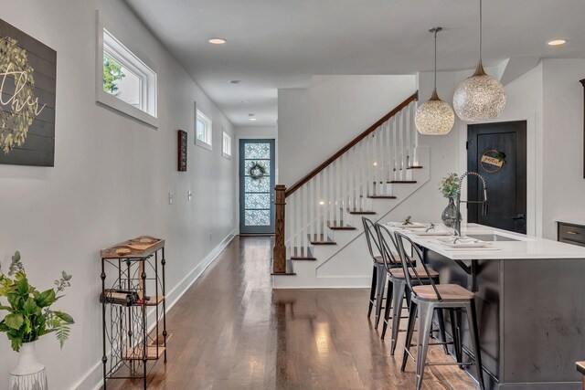 entryway with dark wood-type flooring, stairway, recessed lighting, and baseboards