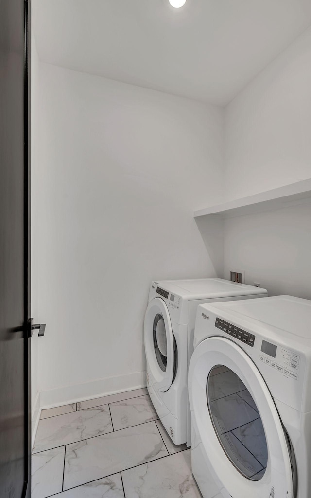 laundry area featuring laundry area, marble finish floor, baseboards, and separate washer and dryer