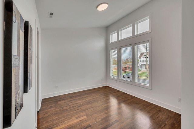 unfurnished room featuring dark wood-style flooring and baseboards