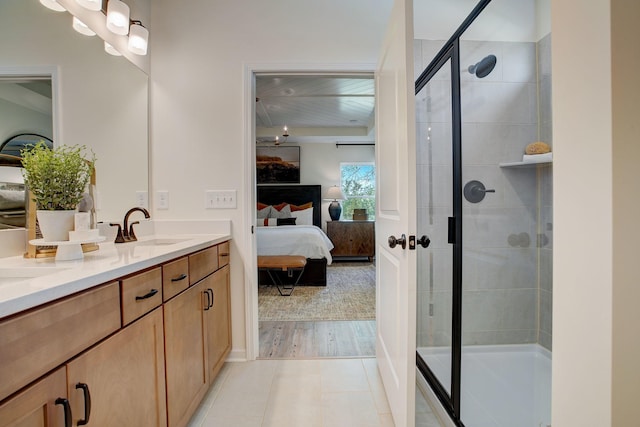 ensuite bathroom featuring a stall shower, ensuite bath, vanity, and tile patterned floors