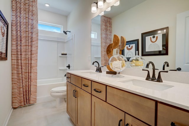 full bath featuring double vanity, a sink, toilet, and tile patterned floors