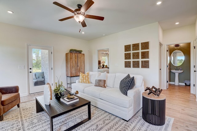 living room featuring ceiling fan, light wood finished floors, baseboards, and recessed lighting