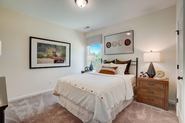 bedroom with light carpet, visible vents, and baseboards