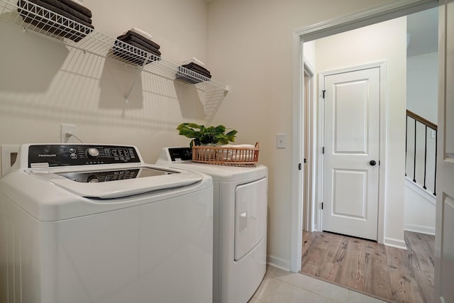 laundry area with laundry area, light wood-style flooring, baseboards, and washer and clothes dryer