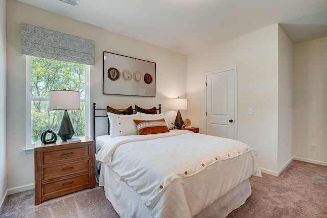 bedroom with light carpet and baseboards