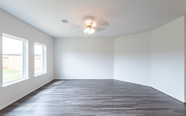 empty room featuring ceiling fan, visible vents, and wood finished floors