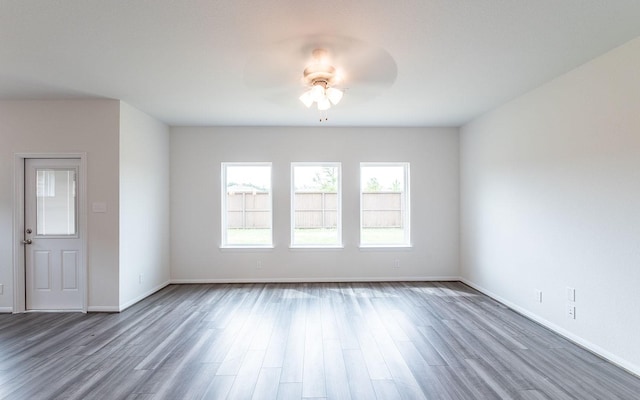 spare room with a ceiling fan, baseboards, and wood finished floors