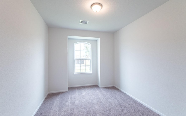 empty room featuring visible vents, baseboards, and carpet flooring