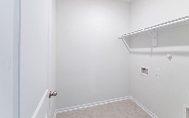 washroom with baseboards, washer hookup, and laundry area