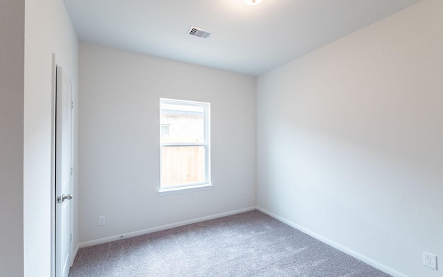 carpeted empty room featuring visible vents and baseboards