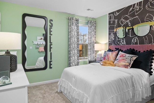 bedroom featuring an accent wall, baseboards, visible vents, and carpet flooring