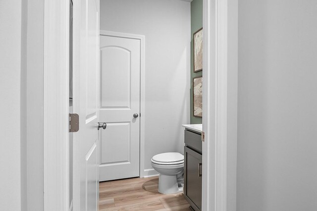 bathroom with vanity, toilet, and wood finished floors