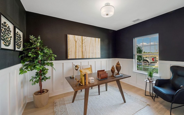 office area featuring visible vents, a wainscoted wall, and light wood finished floors