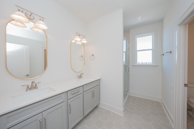 full bathroom with a stall shower, a sink, toilet, and double vanity