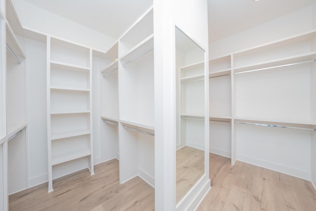 walk in closet with wood finished floors