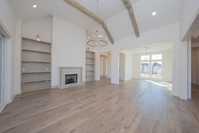 unfurnished living room with an inviting chandelier, light wood-style floors, a fireplace, high vaulted ceiling, and beam ceiling