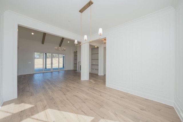 empty room with a notable chandelier, a decorative wall, built in features, light wood-type flooring, and beamed ceiling