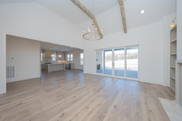 unfurnished living room with a wealth of natural light, beamed ceiling, visible vents, and a notable chandelier