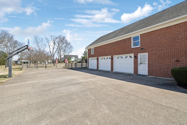 1608 Knox Dr, Brentwood, TN 37027 - view of property exterior featuring a garage, brick siding, driveway, and fence