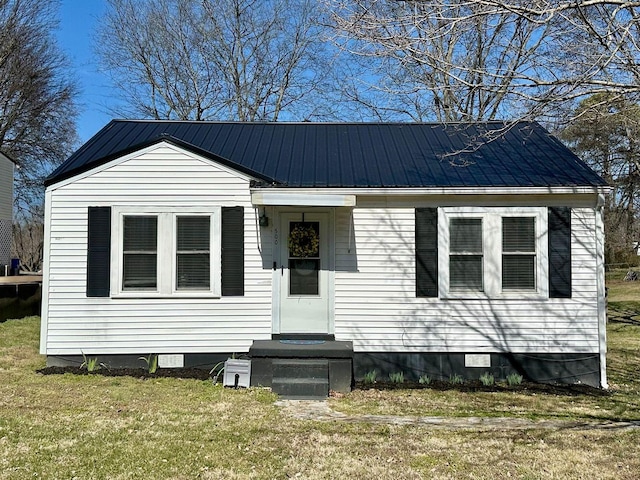 bungalow with metal roof, a front lawn, and crawl space