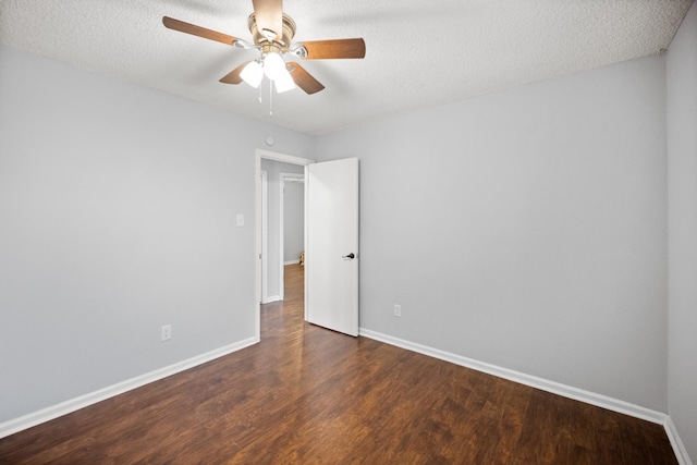 empty room featuring a textured ceiling, baseboards, and wood finished floors