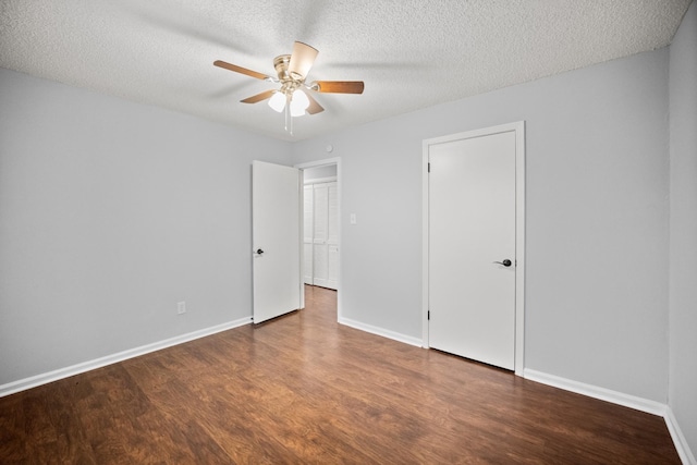 unfurnished bedroom featuring ceiling fan, a textured ceiling, baseboards, and wood finished floors