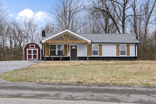 view of front facade with an outbuilding, a garage, a storage unit, a chimney, and a front yard