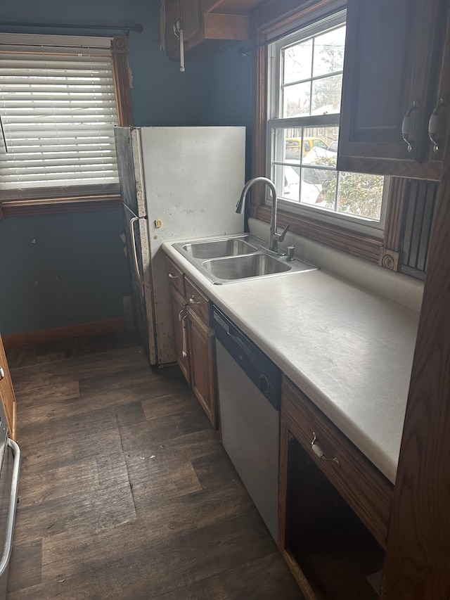 26 Central Ave, Tullahoma, TN 37388 - kitchen with stainless steel dishwasher, freestanding refrigerator, light countertops, a sink, and dark wood-style floors