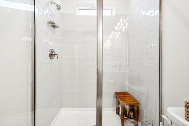 full bath featuring a shower stall and toilet