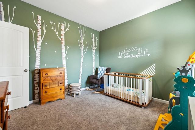 carpeted bedroom featuring a nursery area and baseboards