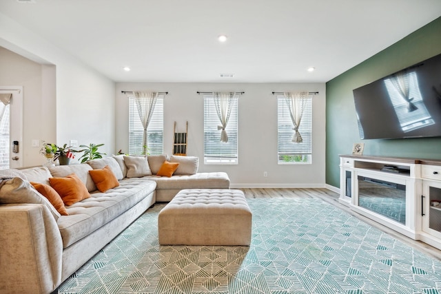 living area with baseboards, light wood finished floors, visible vents, and recessed lighting