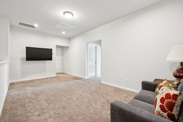 living room with attic access, visible vents, baseboards, and light colored carpet