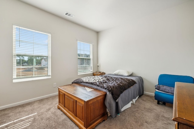 bedroom with light carpet, visible vents, and baseboards