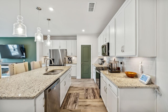 kitchen with visible vents, appliances with stainless steel finishes, light wood-style floors, white cabinetry, and a sink