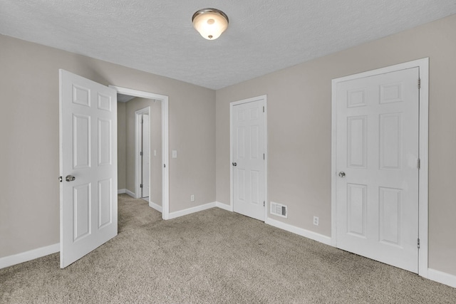 unfurnished bedroom with baseboards, visible vents, and carpet flooring