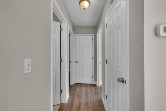 hall with wood finished floors and baseboards