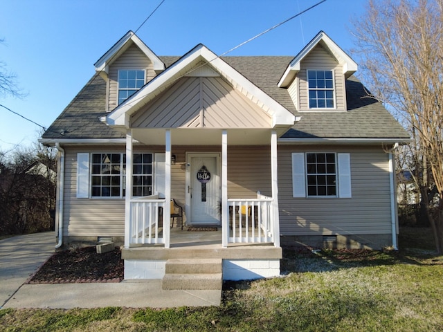 new england style home featuring crawl space, covered porch, and a shingled roof