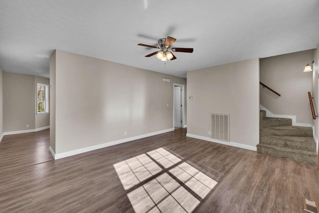 interior space featuring stairway, baseboards, visible vents, and wood finished floors