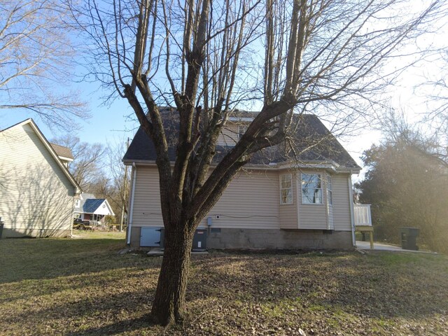 view of side of property featuring a yard and crawl space