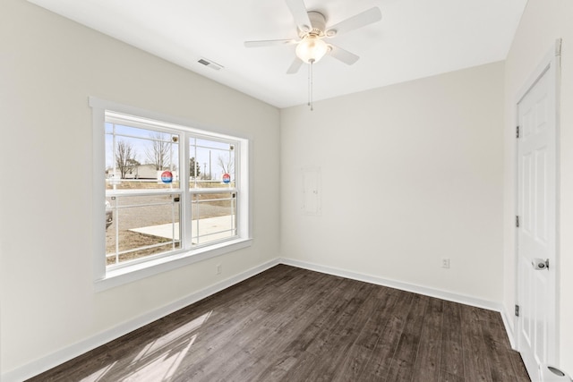 unfurnished bedroom featuring dark wood-style floors, visible vents, baseboards, and a ceiling fan